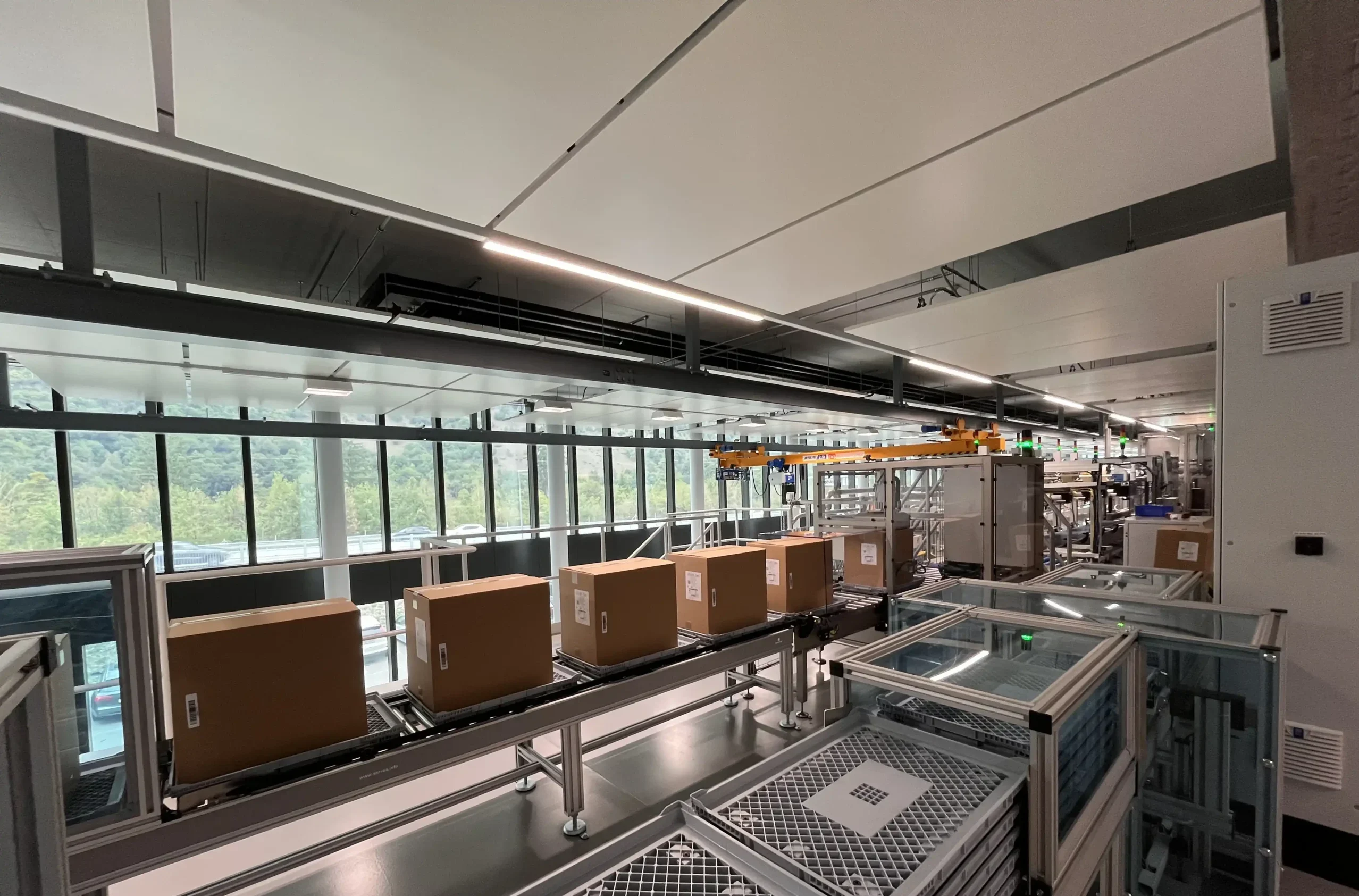 Ein Blick auf die letzte Station einer Niverplast Verpackungs- und Ettiketieranlage bei der Hamilton AG, die fertige Kartons zur Einlagerung oder für den Versand abpackt. So gelingt Lagerautomation.