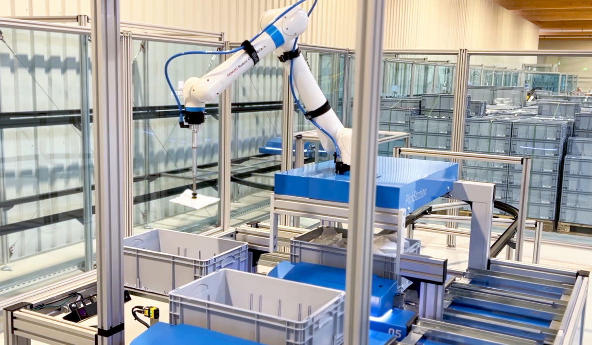 Die Servus PickStation mit einem Pickroboter, der Ware aus einem Behälter kommissioniert – präzise und automatisierte Auftragsabwicklung.