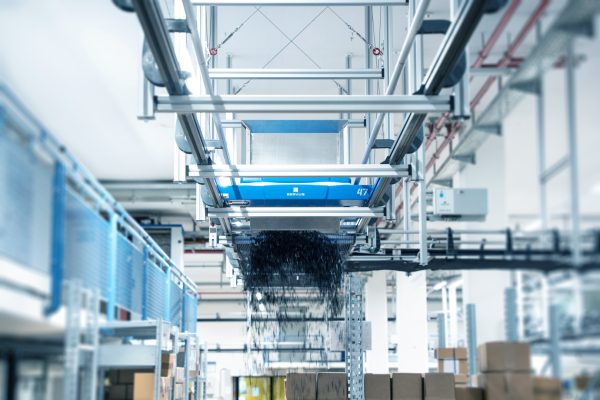 Ein autonomer Transportroboter (ARC) fährt präzise auf einem Schienenleitsystem durch das Lager für eine effiziente Warenbewegung.