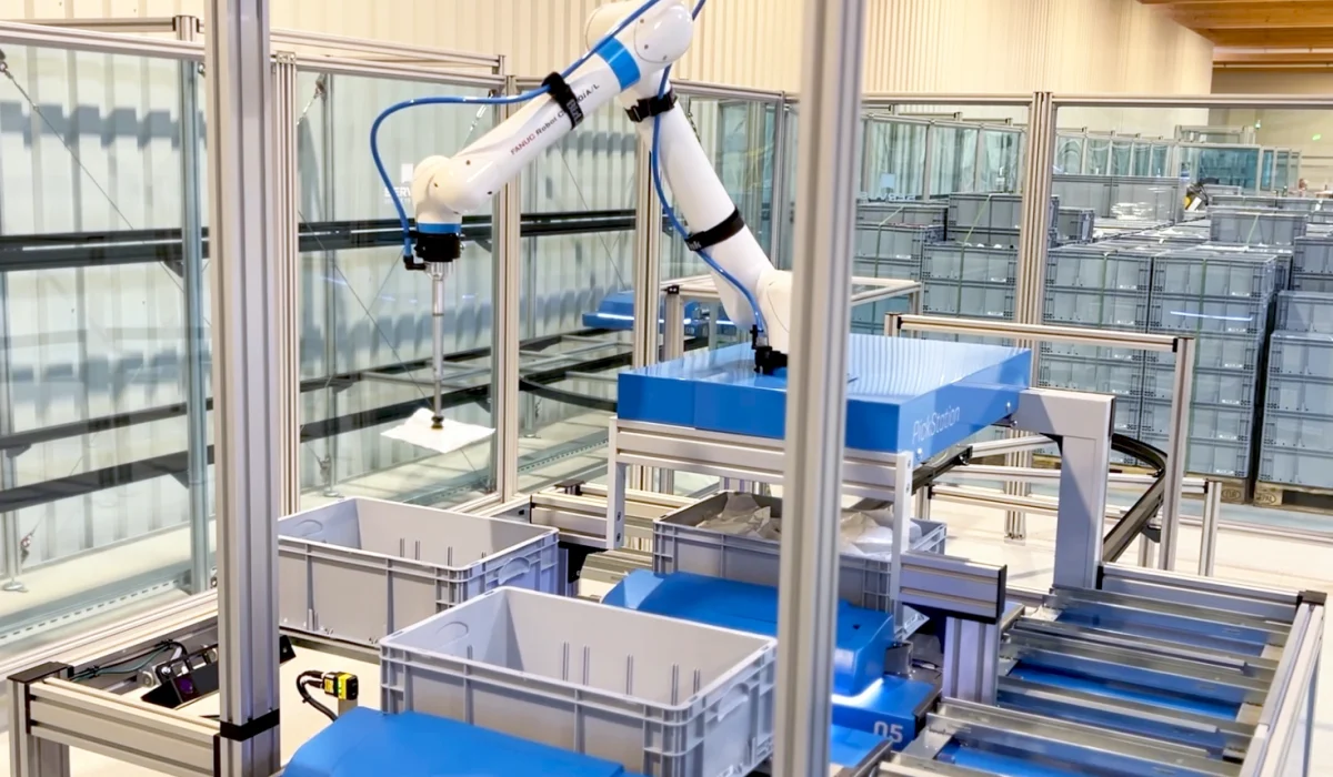 Die Servus PickStation mit einem Pickroboter, der Ware aus einem Behälter kommissioniert – präzise und automatisierte Auftragsabwicklung.